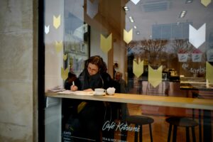 Traveler writing in a physical journal at a cafe in Paris